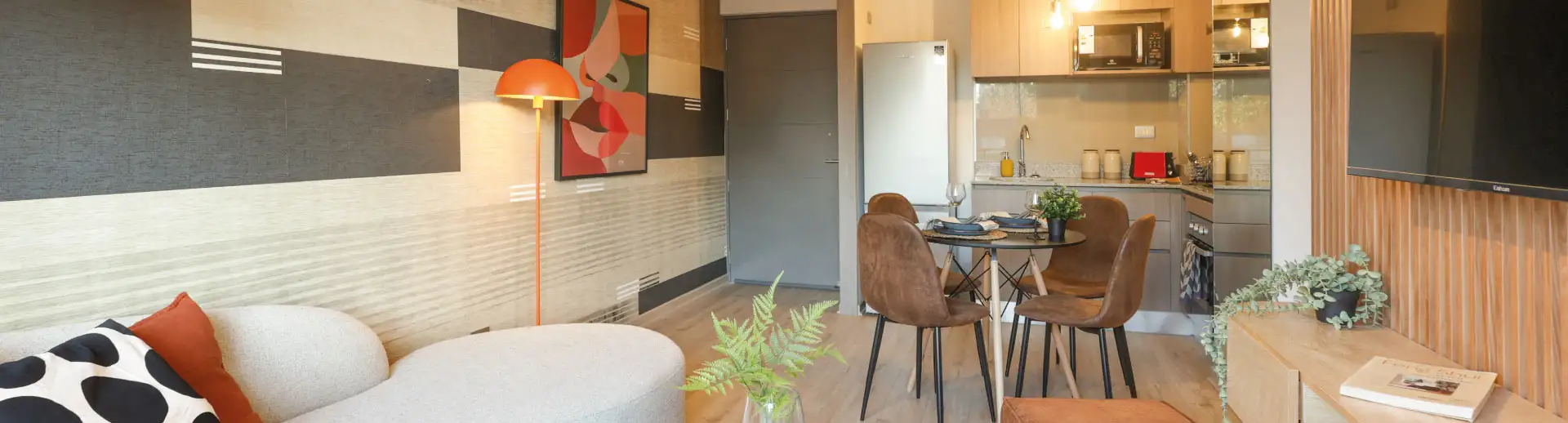 Living y cocina de Edificio Pedro de la Barra en Santiago Centro, mostrando piso SPC y muebles.