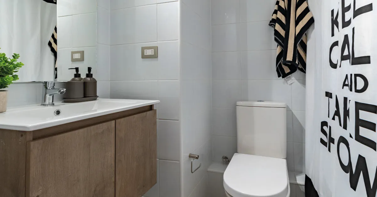 Baño de Condominio Parque del Sur en La Cisterna, mostrando vanitorio con mueble y loza vítrea.