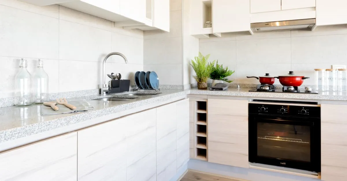 Moderna cocina con cubierta de granito gris Mara en piloto de Condominio Alto Marañón 3.