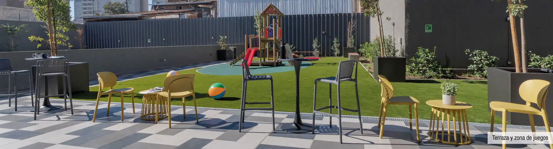Terraza exterior y zona de juegos infantiles en Edificio Briones Luco, La Cisterna, espacios familiares.