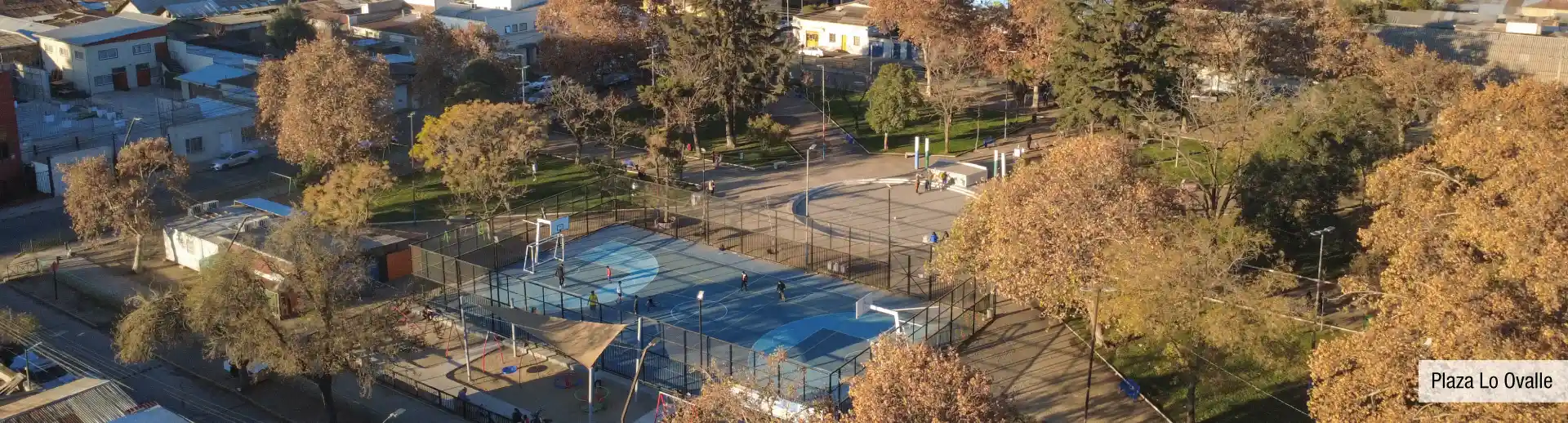 Vista aérea de Plaza Lo Ovalle cerca a Edificio Santa Corina en La Cisterna, mostrando sus multicanchas deportivas.
