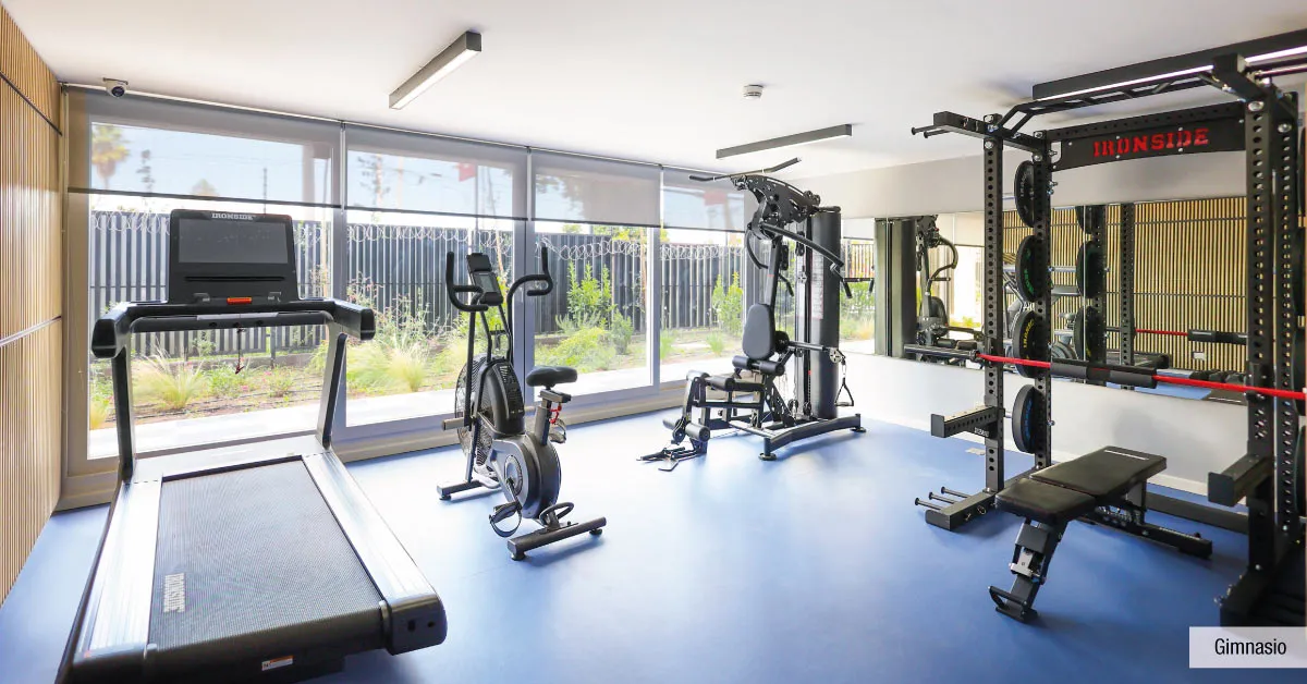 Gimnasio equipado de Condominio Parque del Sur en La Cisterna, mostrando máquinas de ejercicio.