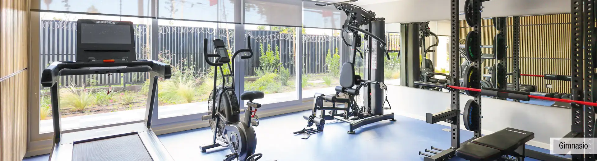 Gimnasio equipado de Condominio Parque del Sur en La Cisterna, mostrando máquinas de ejercicio.