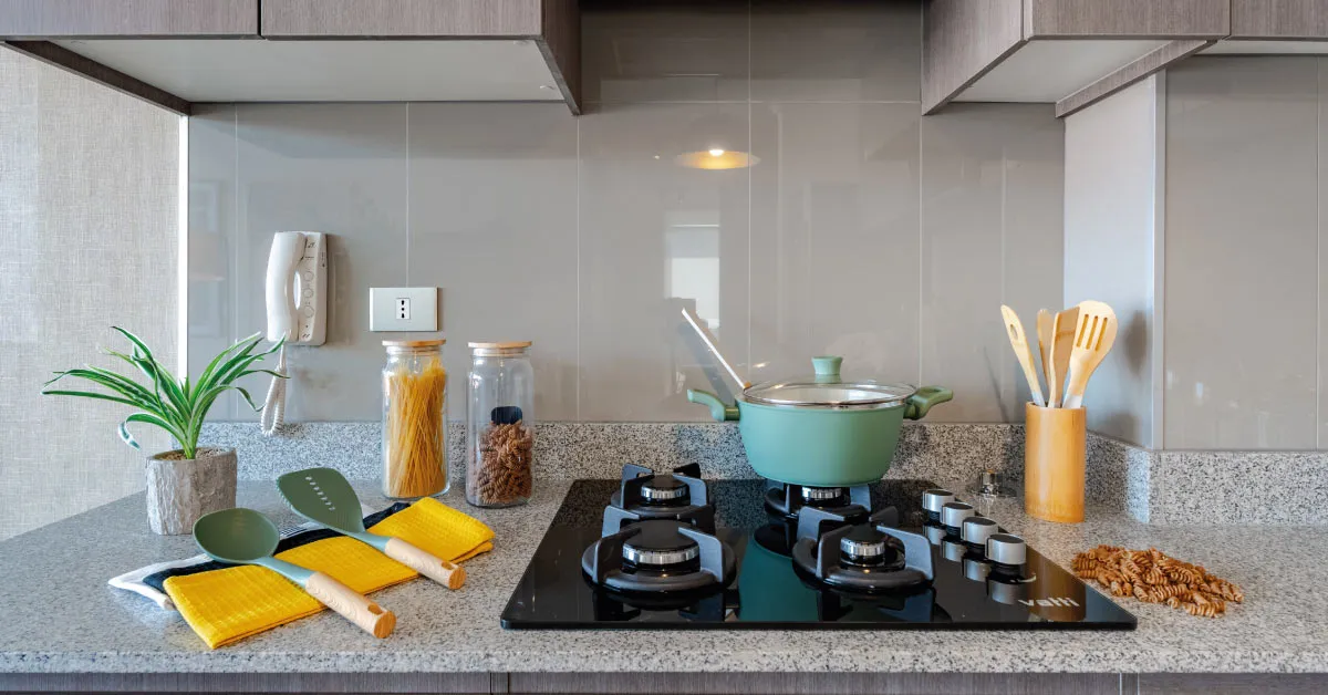 Cocina equipada de Condominio Parque del Sur en La Cisterna, con encimera a gas y cubierta de granito.