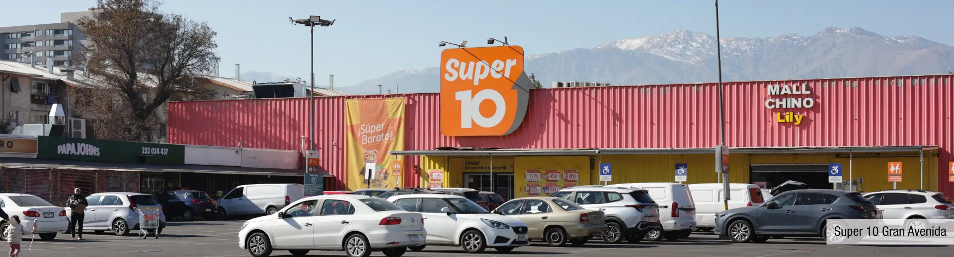 Supermercado Super 10 cercano a Edificio Santa Corina en La Cisterna, mostrando su amplio estacionamiento y comercios.
