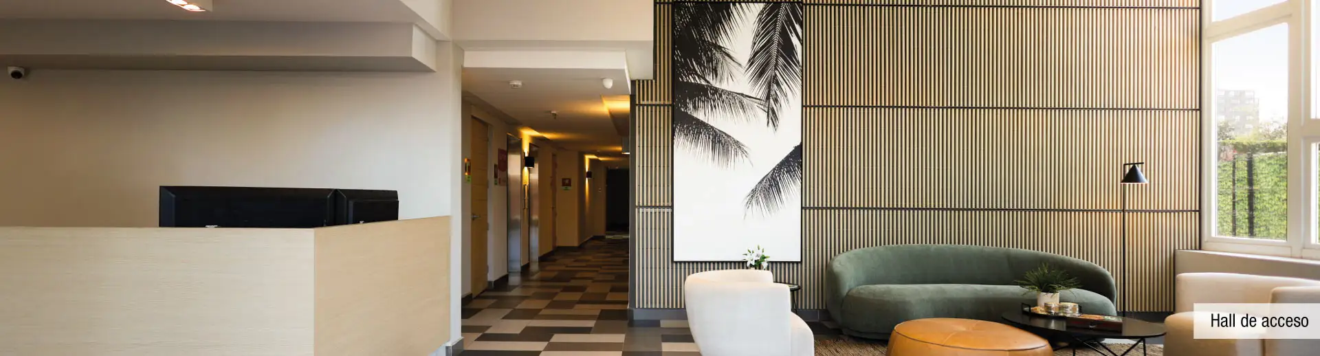 Hall de acceso en doble altura de Condominio Parque del Sur, La Cisterna, con conserjería 24 horas.