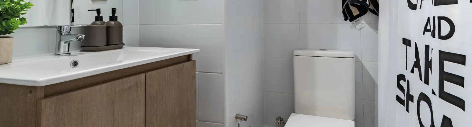 Baño de Condominio Parque del Sur en La Cisterna, mostrando vanitorio con mueble y loza vítrea.