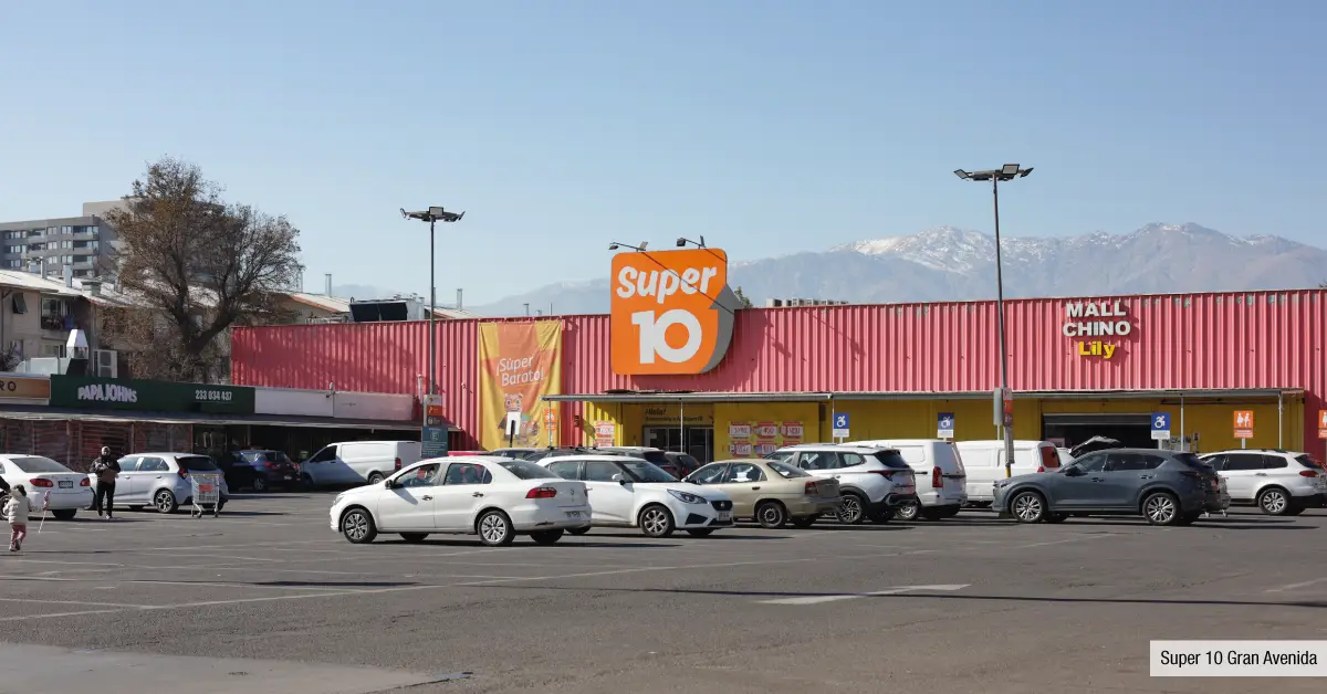 Supermercado Super 10 cercano a Edificio Santa Corina en La Cisterna, mostrando su amplio estacionamiento y comercios.